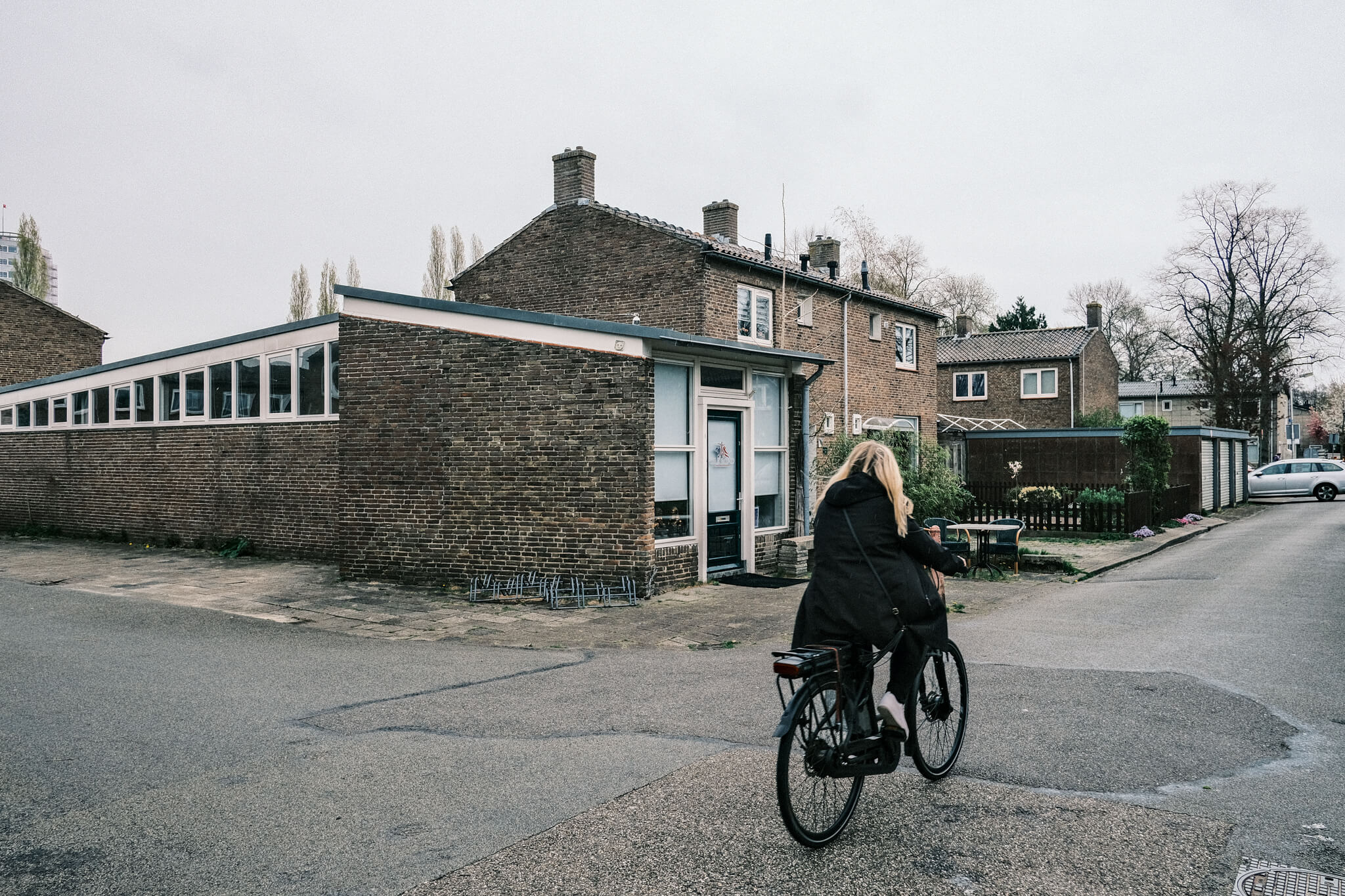 A photo of a woman cycling through the old neighborhood