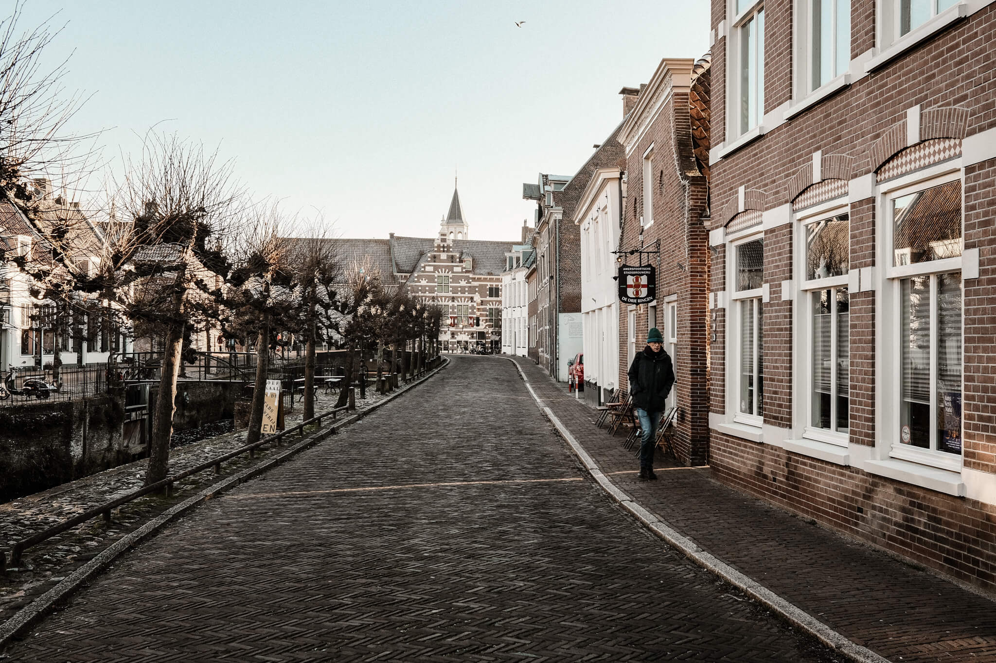 A man walking down the streets of the old city of Amersfoort