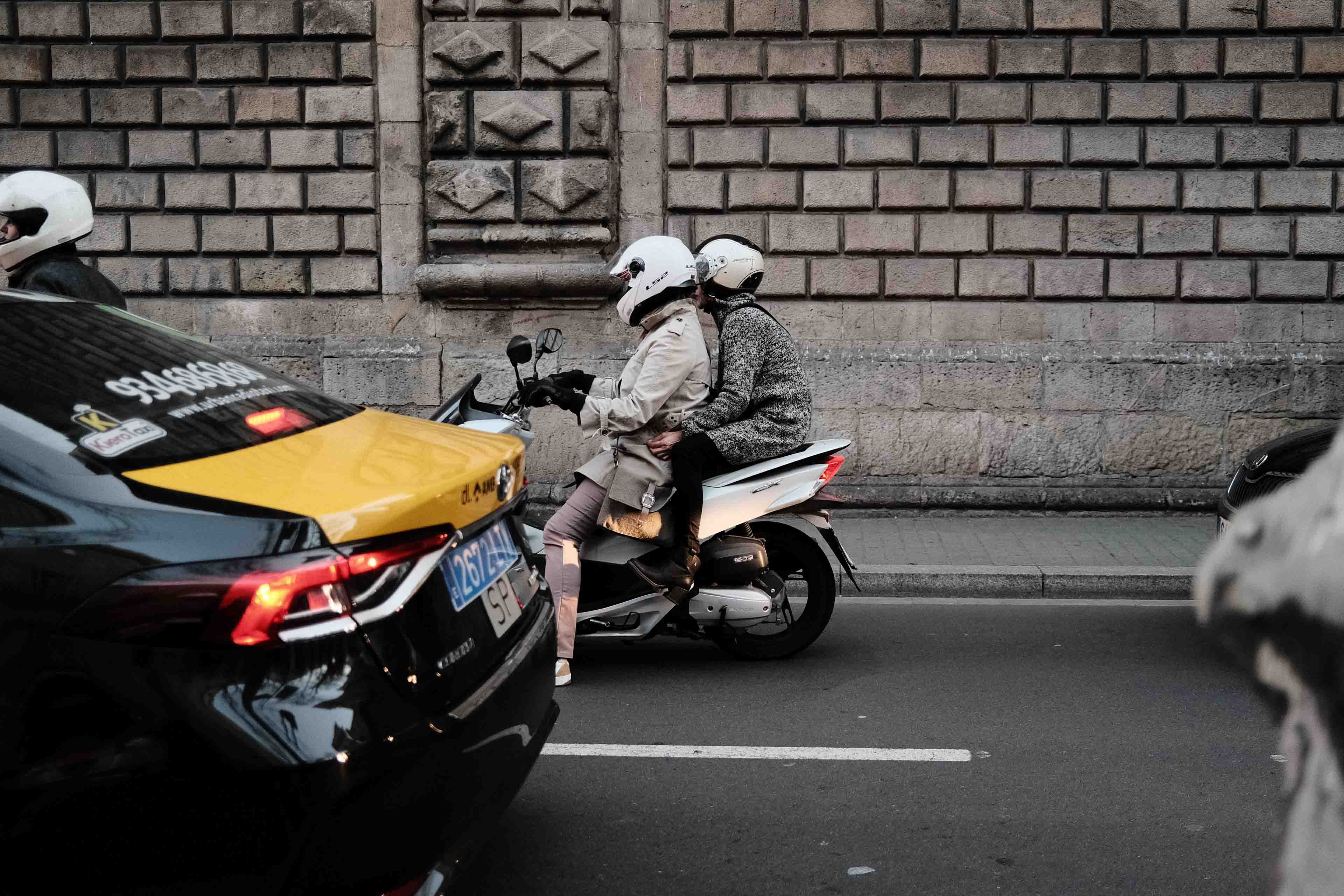 Two people on a scooter in traffic