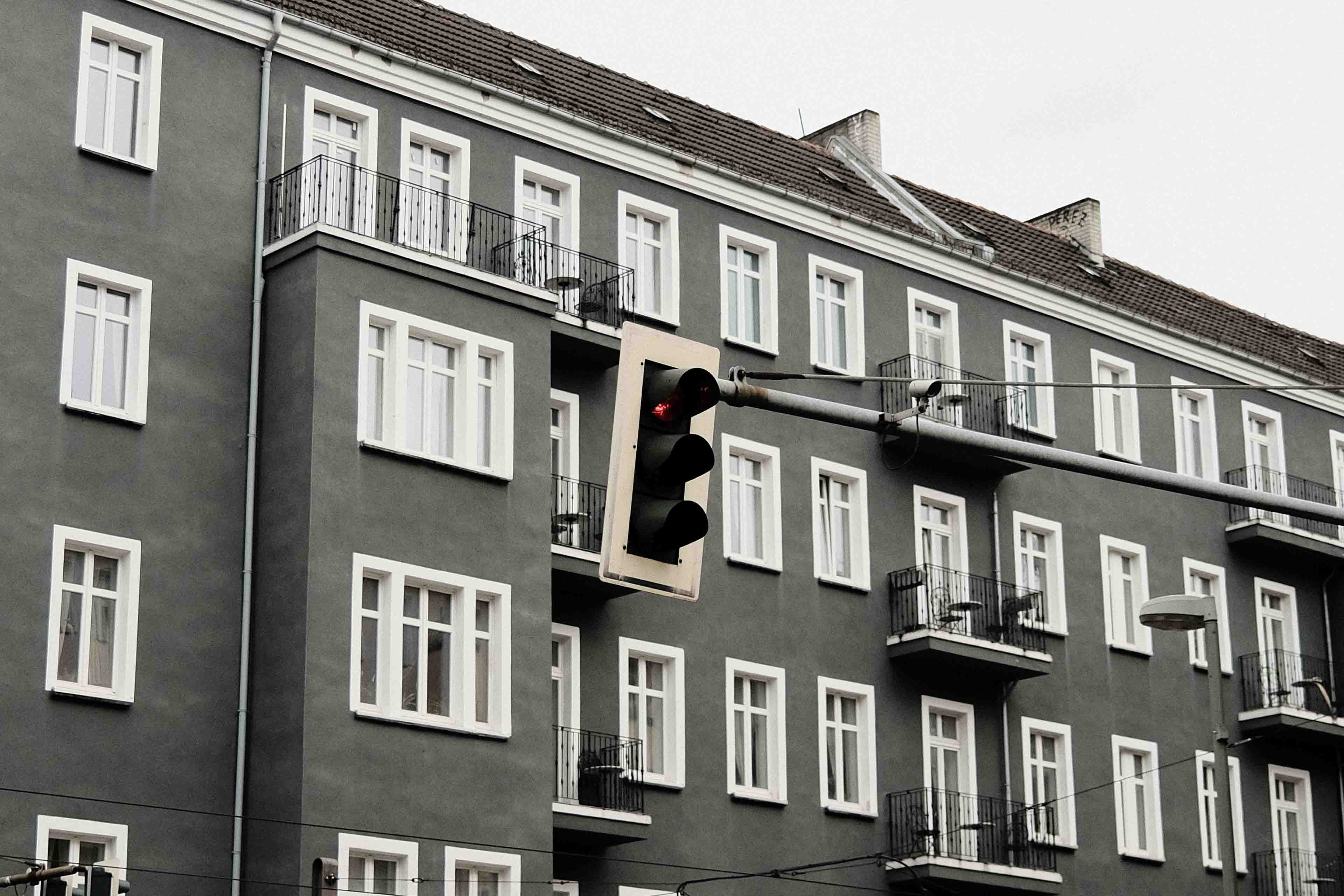 a traffic light aligning with the pattern of windows behind it