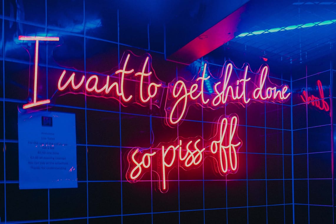 a neon sign saying "I want to get shit done so piss off"